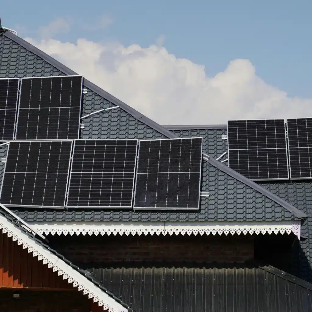 Dark tile roof with installed solar panels and clean rain gutters on a residential property in Hurstville.